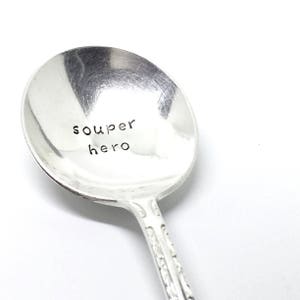 May include: A silver spoon with the words "souper hero" engraved on the bowl.