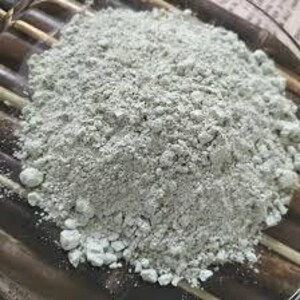 May include: A close-up of a pile of light green powder. The powder is fine and has a slightly grainy texture.
