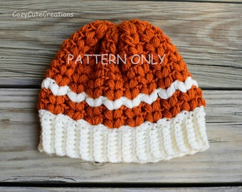 May include: A crocheted hat with a white and orange color scheme. The hat has a textured pattern and a white brim. The text "PATTERN ONLY" is visible on the hat.