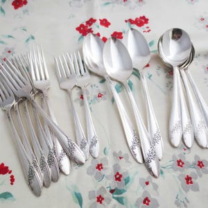 Puede incluir: Un juego de cubiertos vintage, que incluye tenedores y cucharas, con diseños ornamentados. Los cubiertos están hechos de metal plateado y tienen un acabado pulido.