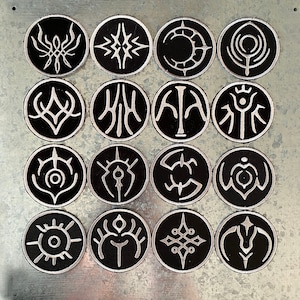 May include: A set of 15 black and white iron-on patches featuring various abstract designs. The patches are circular and have a white outline.
