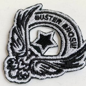 May include: Black and white embroidered patch featuring a star and the text "Buster Bros. Co."