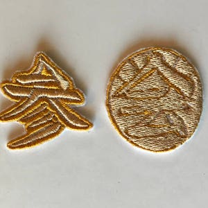 May include: Two gold embroidered patches, one with a stylized design and the other with the Chinese character for "spring".