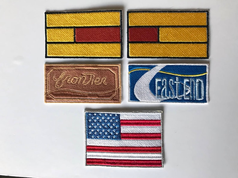 May include: Five embroidered patches, including a brown patch with the text "From The", a blue patch with the text "East End", two yellow patches with red and black stripes, and a red, white, and blue American flag patch.