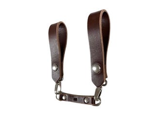 May include: Brown leather camera strap with two adjustable loops and silver metal hardware.