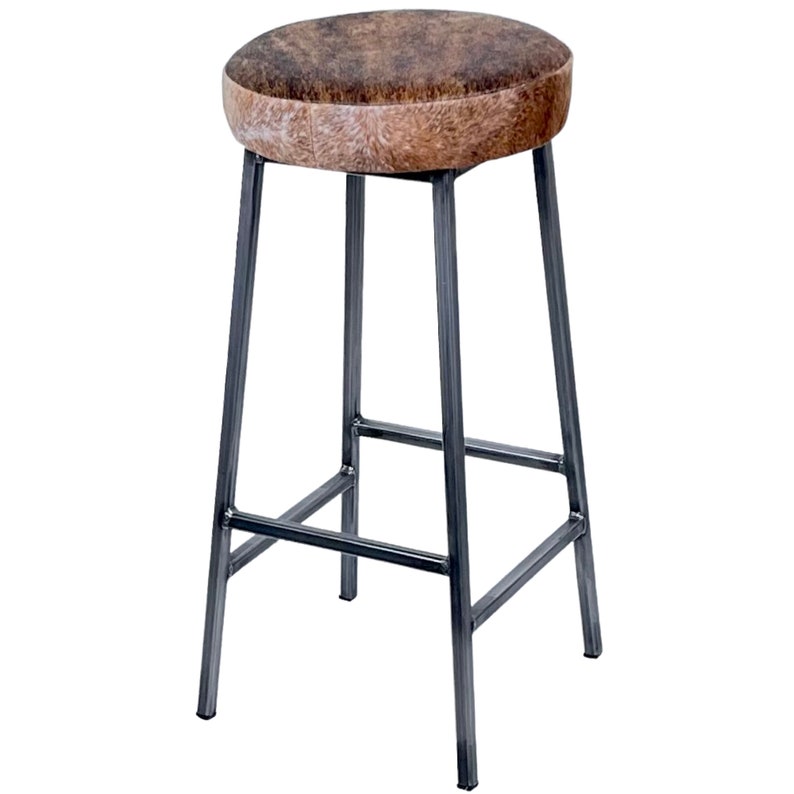 May include: A brown and white cowhide bar stool with a metal frame. The stool has a round seat and a simple design.