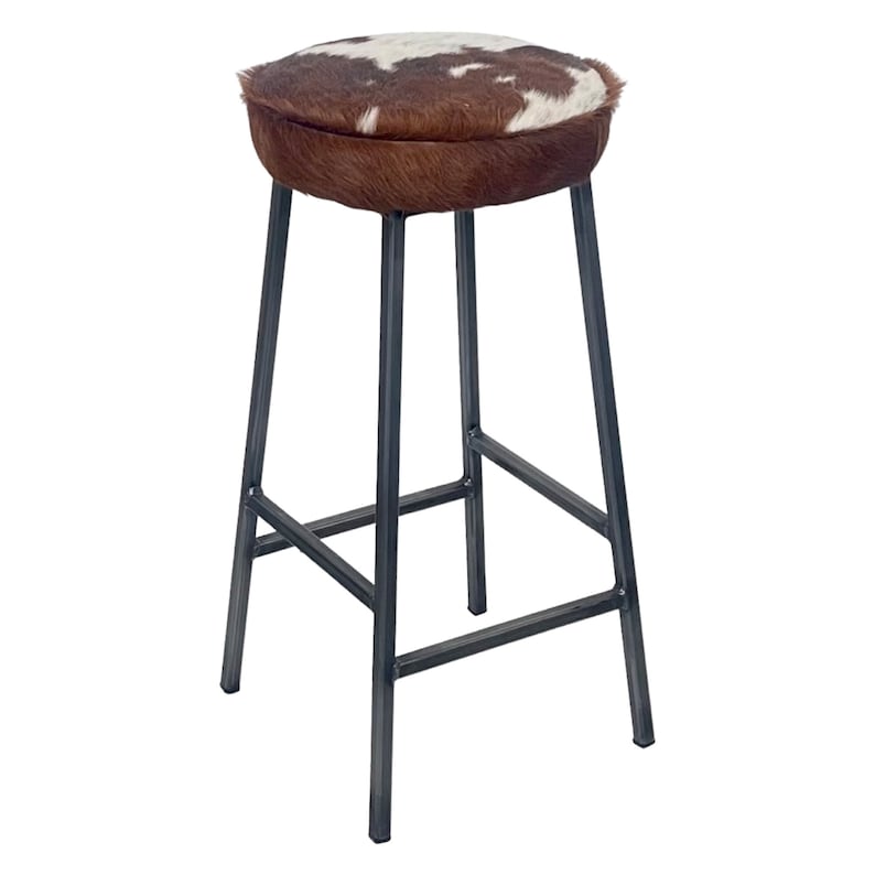 May include: A brown and white cowhide bar stool with a black metal frame.