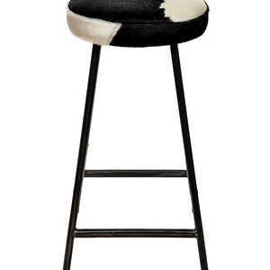 May include: Black and white cowhide bar stool with a black metal frame.
