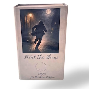 May include: A rectangular box featuring an illustration of a person running down a street at night under a full moon. The text "Steal The Show" is above a circle and the text "Ripper for the show stopper" is below the circle.