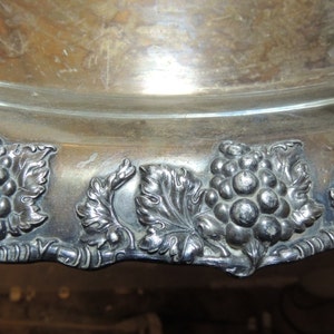 May include: Silver serving tray with a decorative grape and leaf design around the edge.