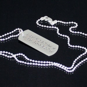 May include: A silver necklace with a silver dog tag pendant. The dog tag has the coordinates 44.652196 N 63.6300327 W engraved on it.