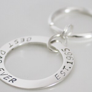 May include: Silver keychain with a round charm that reads "Best Dad Ever Est. 1965".