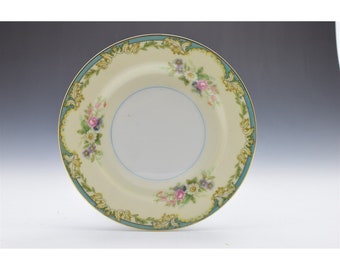 May include: A vintage floral design dinner plate with a cream colored background, blue and gold trim, and a floral pattern in shades of pink, purple, and yellow.