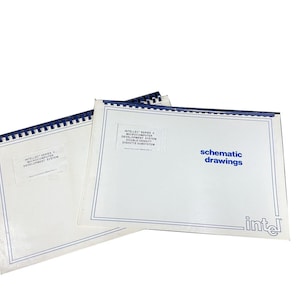 May include: Two white schematic drawing books with blue trim and binding. The text "schematic drawings" is in blue. The Intel logo is in the bottom right corner. The books are labeled "Intel Series II Microcomputer Development System".
