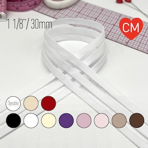 May include: White elastic ribbon, 1 1/8 inches (30mm) wide, is displayed. The ribbon is dyeable and comes in various colors, including black, white, and shades of beige, red, purple, and brown. A measuring tape and pins are in the background.
