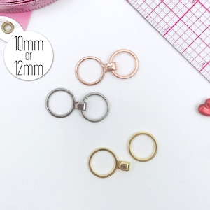 Pode incluir: Três conjuntos de anéis de metal com uma barra de conexão. Os anéis estão disponíveis em ouro, prata e ouro rosa. Os anéis têm um diâmetro de 10 mm ou 12 mm.