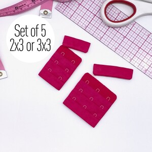 Op de afbeelding: Set van vijf roze bh-verlengstukken met metalen haken. De verlengstukken zijn verkrijgbaar in twee maten: 2x3 of 3x3.