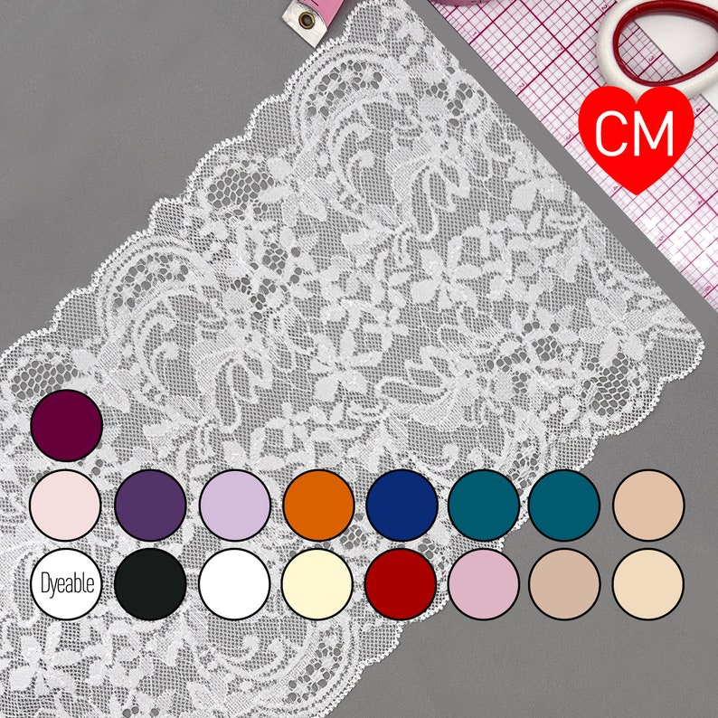 K&ouml;nnte beinhalten: Wei&szlig;e Spitzenborte mit Blumenmuster. Die Borte wird mit verschiedenen Farbmustern gezeigt, darunter Burgunderrot, Rosa, Lila, Lavendel, Orange, Marineblau, T&uuml;rkis und Beige. Die Borte ist mit "F&auml;rbbar" gekennzeichnet.