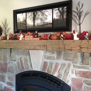 Puede incluir: Una repisa de madera r&uacute;stica con una chimenea de ladrillo debajo. La repisa est&aacute; decorada con follaje de oto&ntilde;o, peque&ntilde;as figuritas y un letrero que dice "Boo!"