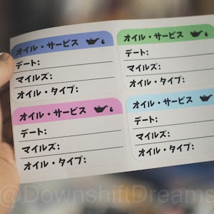 May include: Four oil change reminder cards with a black oil can icon and a drop of oil. Each card has the words "Oil Service" in Japanese, followed by "Date", "Miles", and "Oil Type" with blank lines for filling in the information.
