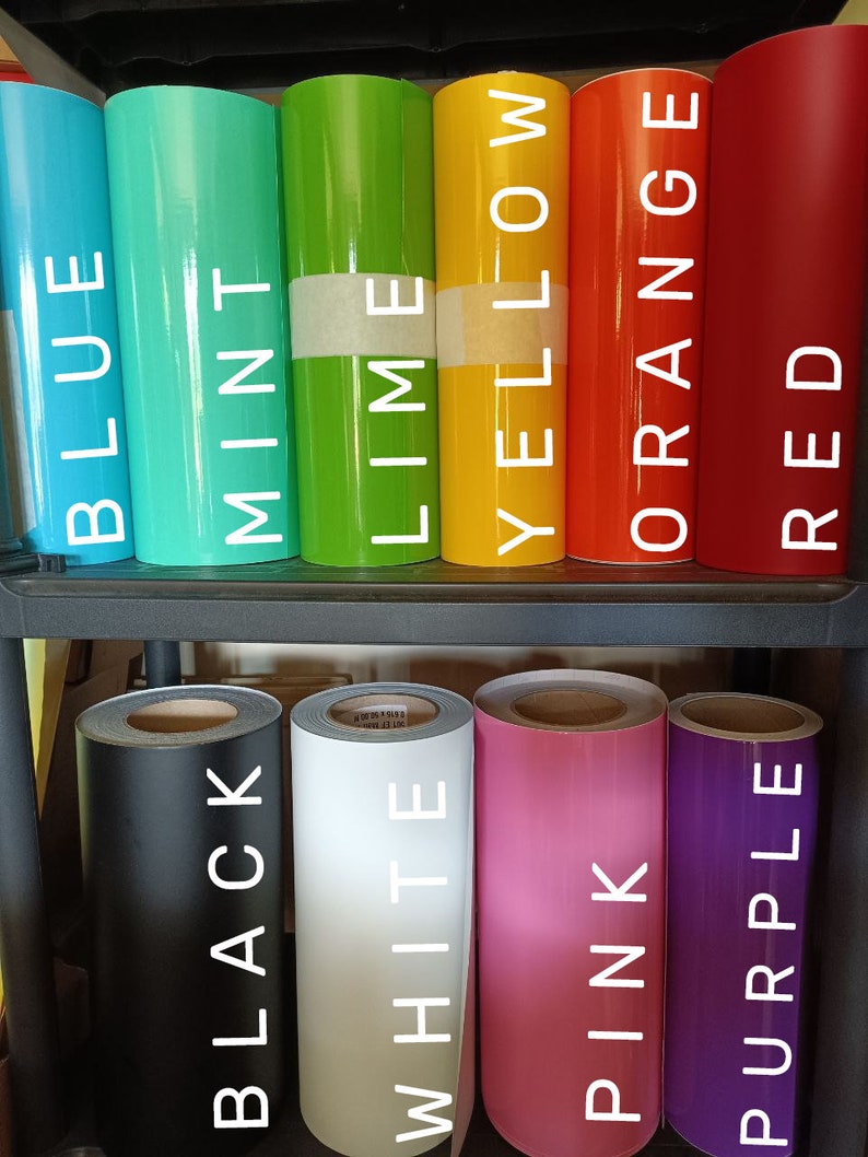 K&ouml;nnte beinhalten: Rollen Vinyl in verschiedenen Farben, darunter Blau, Minze, Limette, Gelb, Orange, Rot, Schwarz, Wei&szlig;, Rosa und Lila. Die Rollen sind mit dem Farbnamen beschriftet.