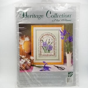 May include: Cross stitch pattern for a floral design featuring purple irises in a gold frame. The pattern is titled "Iris Mosaic" and is part of the "Heritage Collection" by Elsa Williams.