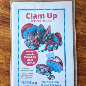 May include: A brochure for "Clam Up" zippered pouches, featuring various sizes and designs. The pouches are primarily blue and red with floral patterns. Text includes "Extra easy and fun to make" and a coupon for a video tutorial.