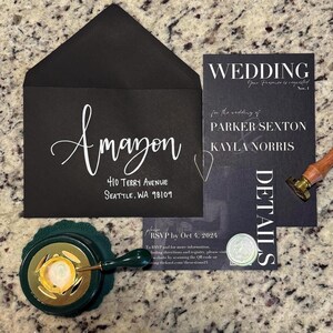 May include: Black and white wedding invitation with the text "WEDDING" in bold, followed by "Your Presence is requested" and "Nov. 1". The invitation also includes the names "PARKER SEXTON" and "KAYLA NORRIS" in white text. The invitation is on a black background with a white wax seal.