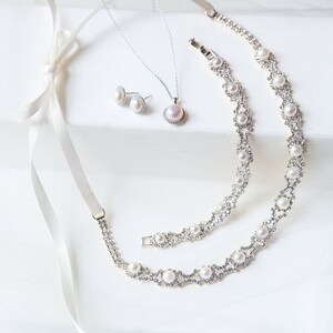 Puede incluir: Un conjunto de joyas de perlas que incluye un collar, una pulsera y pendientes. Las joyas est&aacute;n hechas de plata y tienen un dise&ntilde;o delicado con peque&ntilde;as perlas y pedrer&iacute;a.
