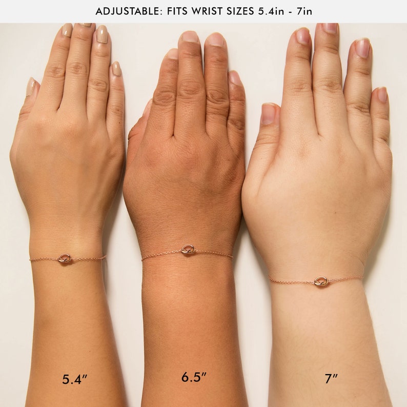 May include: Three wrists wearing a rose gold chain bracelet with a small knot charm. The wrists are labeled with their sizes: 5.4 inches, 6.5 inches, and 7 inches.  Adjustable: Fits wrist sizes 5.4in - 7in