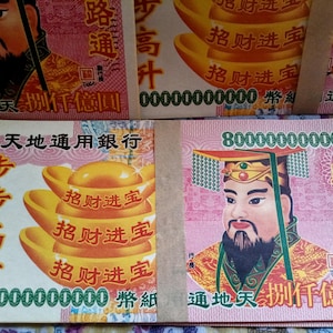 May include: Stacks of colorful Chinese Joss paper featuring illustrations of a man with a beard and gold ingots. The paper has Chinese characters and the number 8000000000000. The background is pink and white.