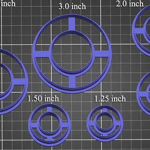 May include: Set of 8 blue plastic cookie cutters in various sizes, ranging from 1 inch to 3 inches in diameter. Each cutter features a double ring design with a center circle and four spokes.