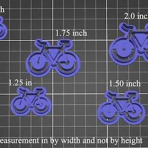 以下が含まれることがあります： さまざまなサイズの青い自転車型の切り抜きが5つあり、幅は2.5〜5.1cmです。切り抜きはグリッドの背景に表示されます。下部のテキストは「幅で測定し、高さではありません」と書かれています。