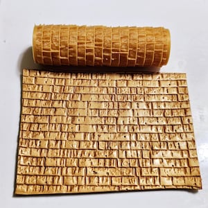 May include: A brown rubber rolling pin with a brick pattern for creating textured designs on fondant or clay.