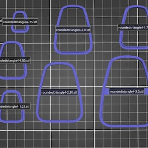 May include: Nine different sizes of purple candy cane cookie cutters, labeled with their size and file name. The cookie cutters are arranged in a grid pattern on a gray background.