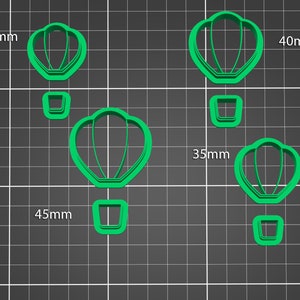 May include: Set of four green plastic cookie cutters shaped like hot air balloons. The cutters are 30mm, 35mm, 40mm, and 45mm in size.