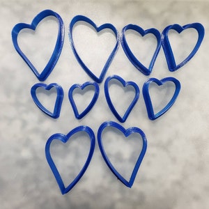 May include: A set of ten blue plastic heart-shaped cookie cutters of various sizes.