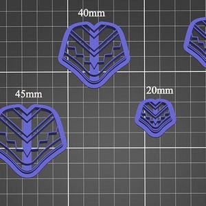 Peut inclure: Six emportes-pièces en plastique violet de différentes tailles, allant de 20 mm à 45 mm, en forme de visage stylisé avec des motifs géométriques.