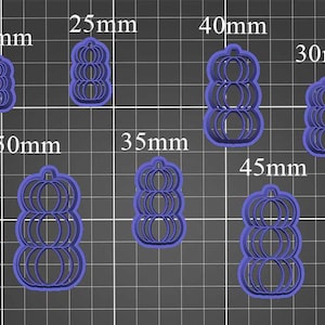 Puede incluir: Un conjunto de cortadores de galletas con forma de calabaza de plástico azul, en varios tamaños, que van desde 20 mm hasta 50 mm. Los cortadores están dispuestos sobre un fondo de cuadrícula gris oscuro, con las medidas en milímetros.