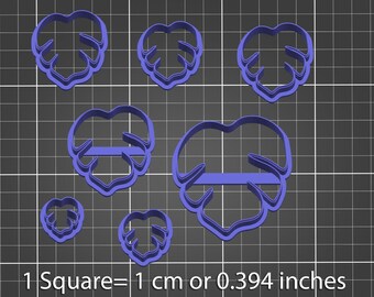 Puede incluir: Conjunto de siete cortadores de galletas de plástico azul con forma de hojas de monstera. Los cortadores están dispuestos sobre un fondo de cuadrícula gris. 1 Cuadrado = 1 cm o 0,394 pulgadas.