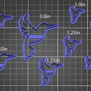 May include: A collection of blue hummingbird-shaped cookie cutters in various sizes, ranging from 1.0 inches to 3.0 inches. The cutters are arranged on a grid background, showcasing their different dimensions.