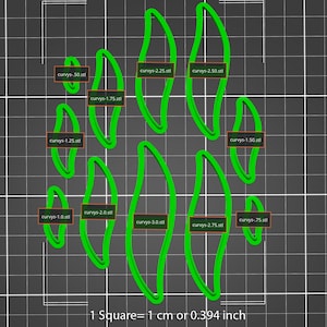 May include: A set of ten green leaf-shaped cookie cutters of varying sizes, labeled with their corresponding sizes in inches. The cookie cutters are arranged in a staggered pattern on a gray grid background. The text "1 Square = 1 cm or 0.394 inch" is printed below the cookie cutters.
