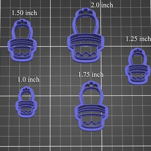 Może przedstawiać: Cztery niebieskie plastikowe foremki do ciasteczek w kształcie kaktusa w doniczce. Foremki mają rozmiary 2,54 cm, 3,18 cm, 3,81 cm, 4,45 cm i 5,08 cm.