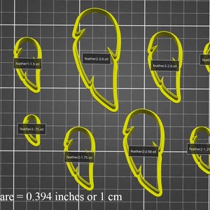 Puede incluir: Ocho cortadores de galletas de diferentes tamaños en forma de pluma. Los cortadores son amarillos y se muestran sobre un fondo de cuadrícula gris. El texto "1 Cuadrado = 0,394 pulgadas o 1 cm" está en la parte inferior de la imagen.