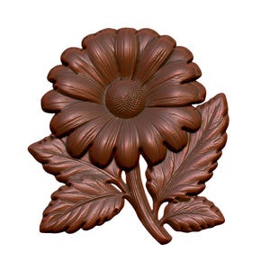 May include: A brown wooden carved flower with leaves. The flower has a large center and many petals.
