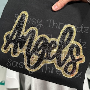 May include: Black sweatshirt with a gold and black sequined design that says "Girls".
