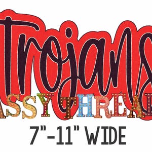 May include: Red and black "Trojans" sign with a colorful "SASSY THREADZ" banner below. The sign is 7-11 inches wide.