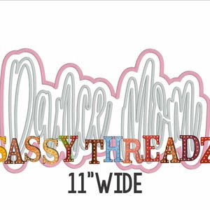 May include: A white graphic with the words "Dance Mom" in a cursive font, outlined in pink. Below, the text "SASSY THREADZ" is in colorful, decorative letters. The text "11" WIDE" is at the bottom.