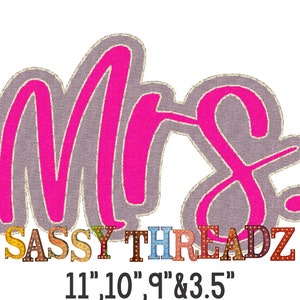 Op de afbeelding: Een roze "Mrs." bord met een grijze achtergrond en de tekst "SASSY THREADZ" in kleurrijke letters met gloeilampen. De tekst "11' 10' 9' & 3.5" staat onder het bord.