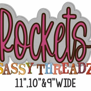 May include: Pink "Rockets" lettering with a brown outline, below the text is "SASSY THREADZ" in colorful block letters with light bulbs, and the text "11", "10", & "9" WIDE" in black.